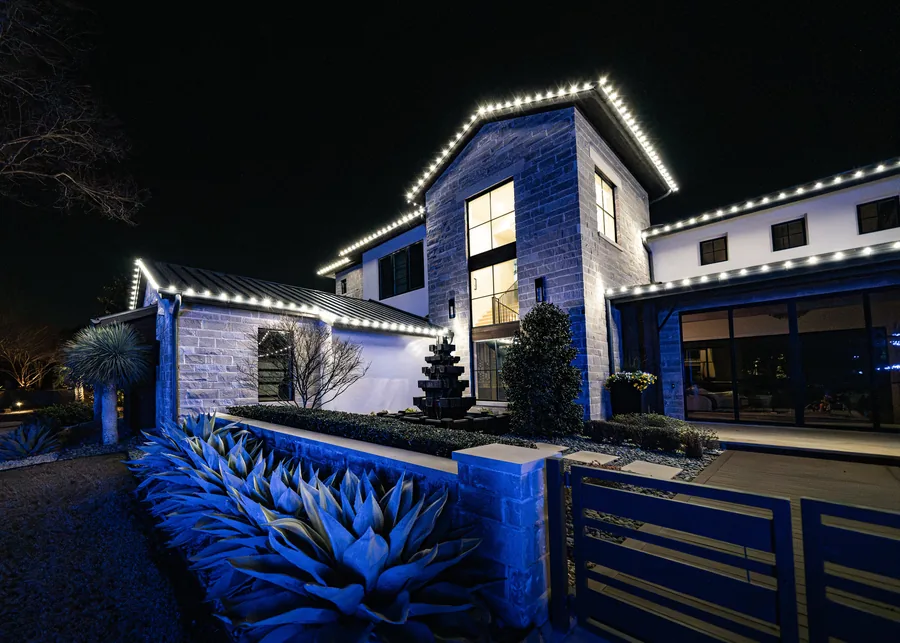 Professionally installed Christmas roofline lights on a Fort Worth home at night