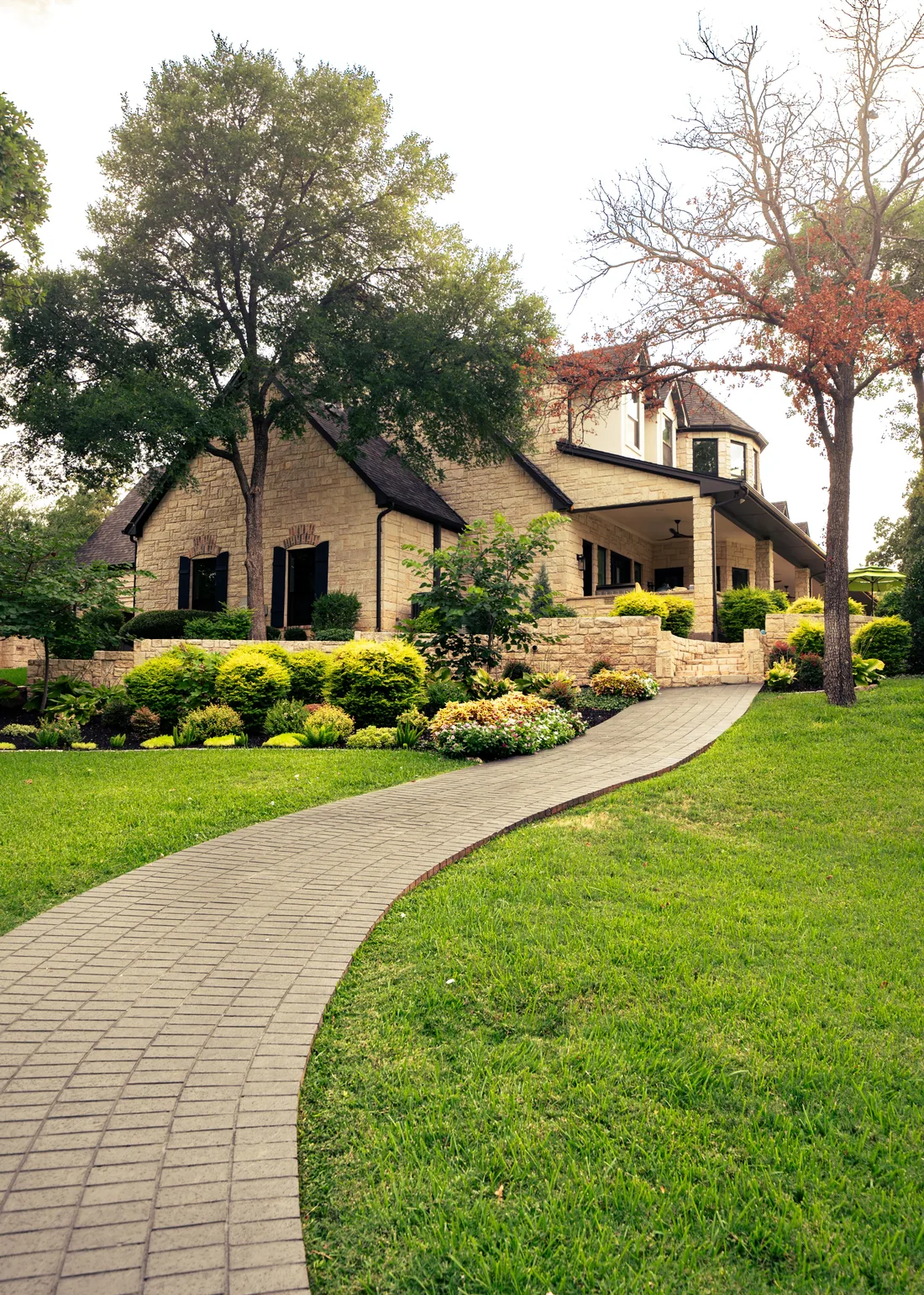 Manicured green front lawn and curved driveway at a Fort Worth home