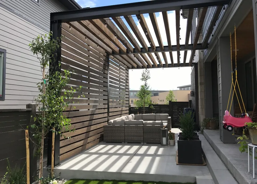 Modern steel and wood pergola with slatted privacy screen over a concrete patio in Fort Worth